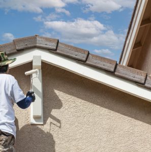 Professional Painter Using A Roller to Paint House Details.